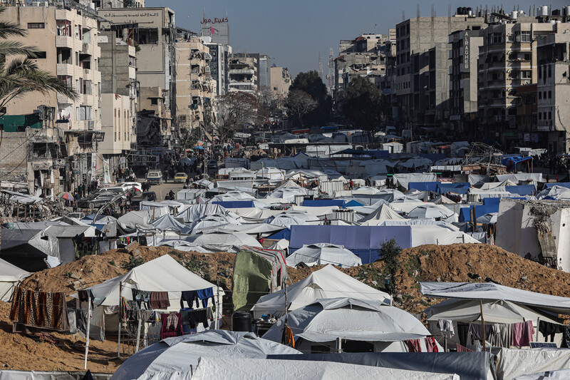White tents fill an open area between multi-story buildings